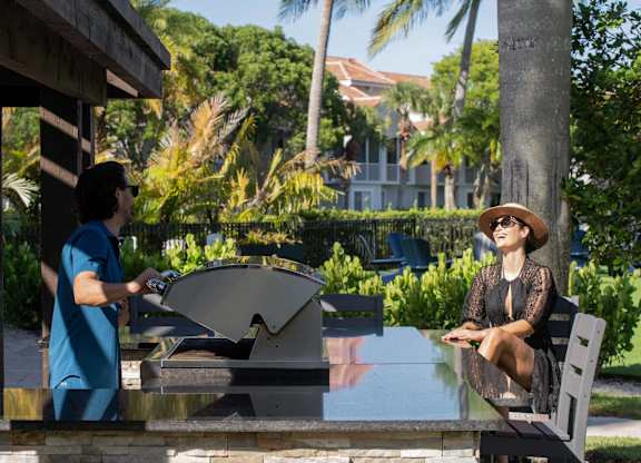 One person uses the outdoor grill while another sits at the counter.