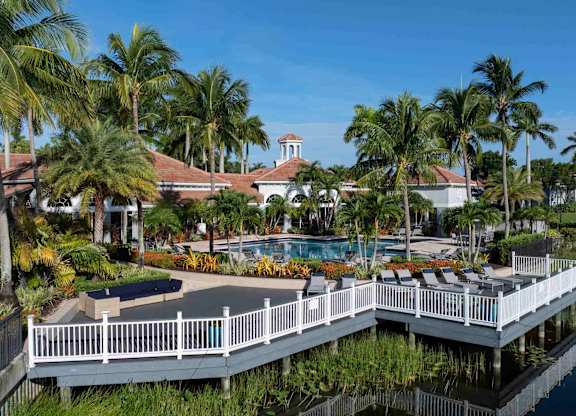 Lakefront deck with white railings beside the pool and clubhouse.