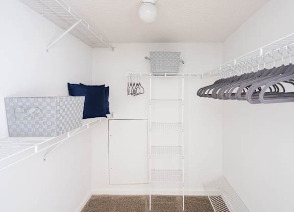 Walk-in closet with wire shelving, hanging rods, and open floor space.