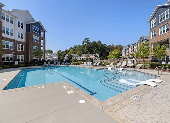 A large swimming pool surrounded by apartment buildings.