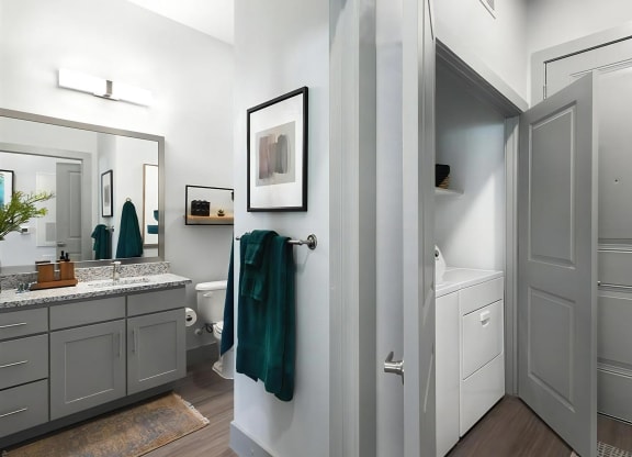 Entryway View Showing Bathroom with Granite Countertop and In-Unit Laundry Closet