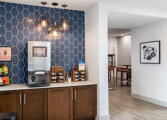 Rhythm Coffee and Tea Bar with A coffee machine on a counter with a blue tile wall behind it.