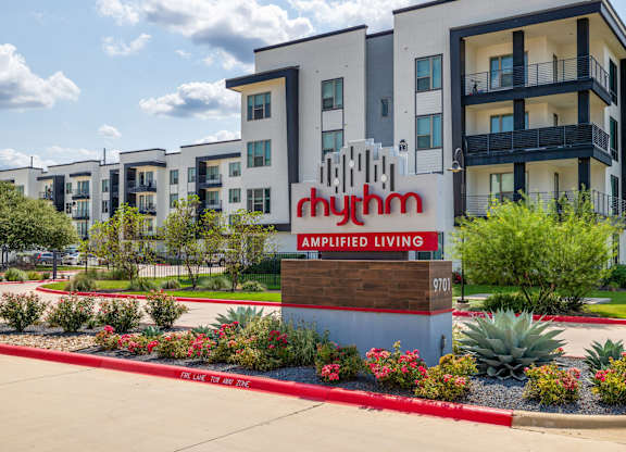 Rhythm Exterior Sign with landscaping and oversized balcony
