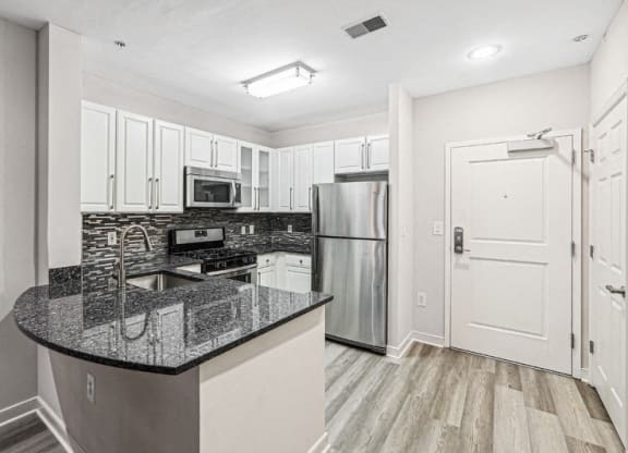 a kitchen with granite counter tops and stainless steel appliances