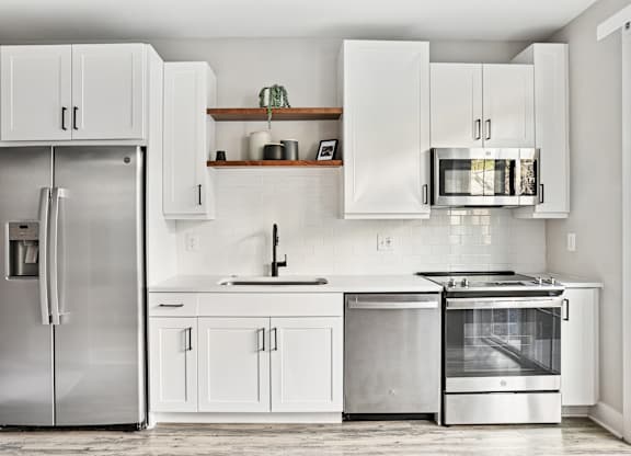 A modern kitchen with a stainless steel refrigerator and oven.