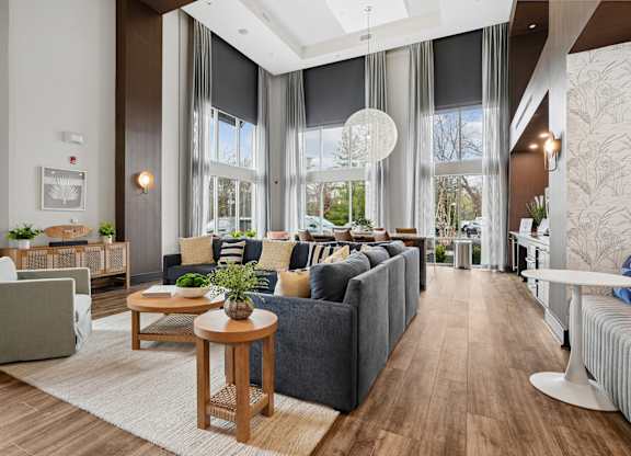 A modern living room with grey couches and wooden furniture.