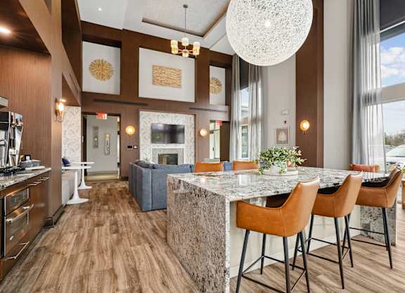 A modern kitchen with a marble island and wooden floors.