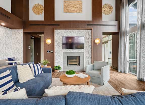 A living room with a blue couch and a fireplace.