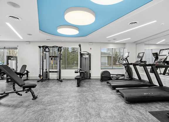 A gym with treadmills, weights, and exercise equipment.