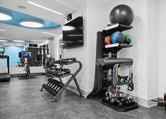 A gym with a variety of equipment including weights and exercise machines.