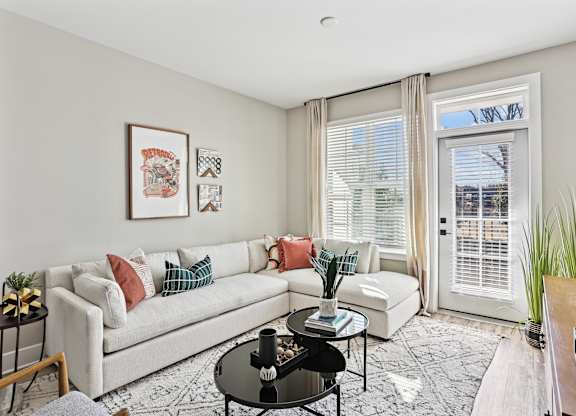 A living room with a white couch, a coffee table, and a rug.