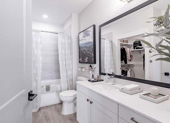 Full bathroom with a bathtub with tile backdrop at Novel Cary