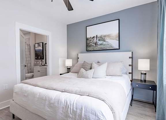 Modern bedroom with ceiling fan and en-suite bathroom at Novel Cary