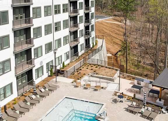 Large outdoor saltwater pool with deep and shallow areas and lounge seating at Novel Cary