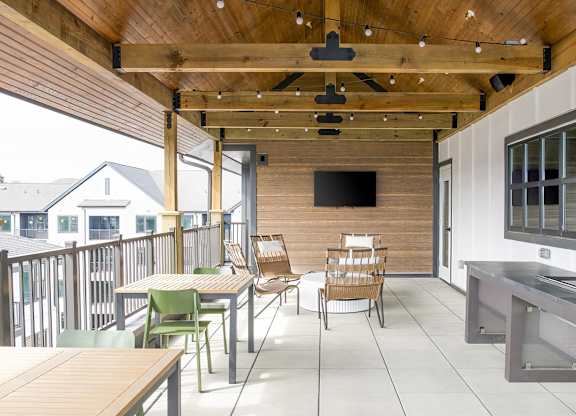 Social elevated outdoor space with seating and string lights at Novel Cary
