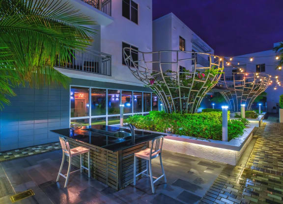 Lit Patio Lounge Featuring Greenery and Sculptural Elements at South of Atlantic