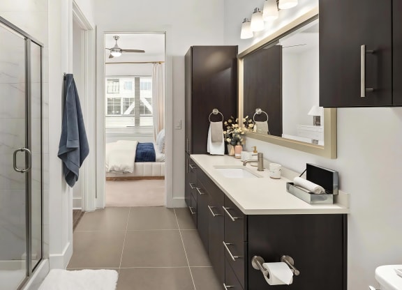 Ensuite Bathroom with Modern Cabinetry, Lighting, and Ample Counter Space