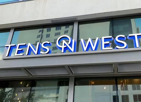 Close-Up of Tens on West Apartment Name on Glass Building Facade