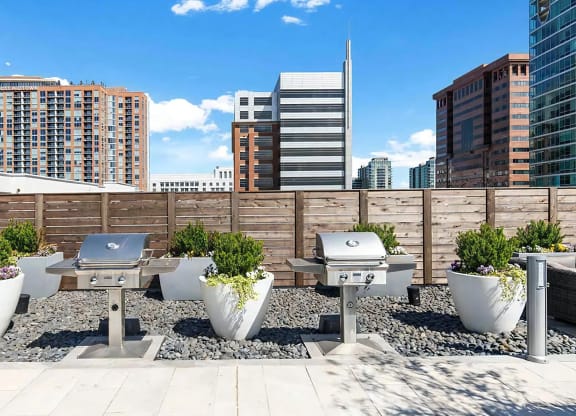 Outdoor Grill Area on Rooftop Deck With Privacy Fence and Seating