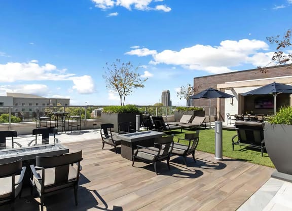 Rooftop Lounge Area With Fire Pits, Seating, and Shade Umbrellas