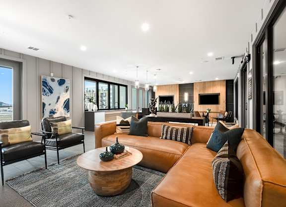 Stylish Resident Lounge with Cozy Sectional, Accent Chairs, and Wall-Mounted TVs