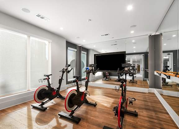 Fitness Studio with Spin Bikes, Wall Mirror, and Mounted TV