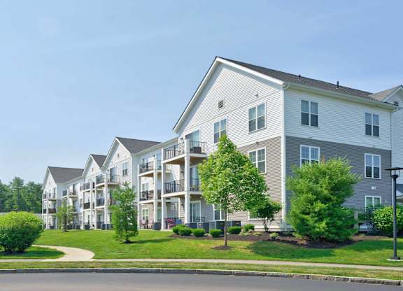 Apartment building with balconies and landscaped grounds at The Madison at Marshfield.