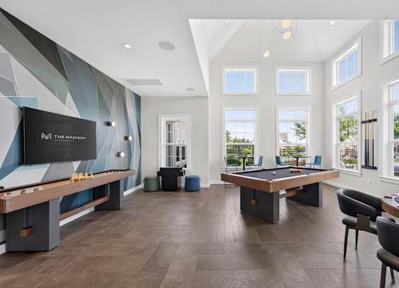 Game room with pool and shuffleboard tables at The Madison at Marshfield.