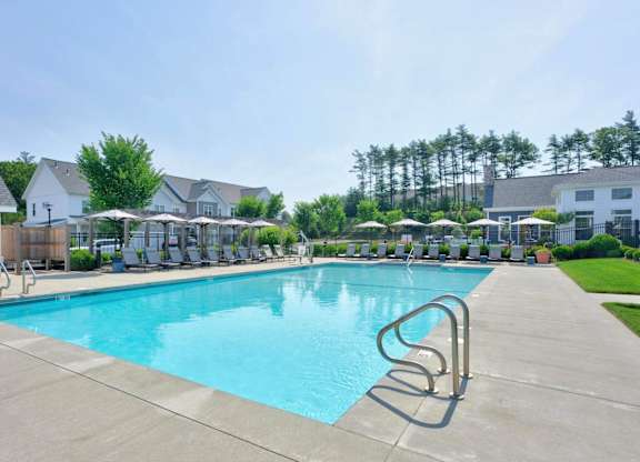 Saltwater pool with lounge seating and apartment buildings at The Madison at Marshfield.