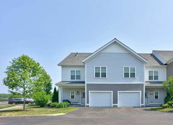 Gray townhomes with individual entrances and attached garages at The Madison at Marshfield.