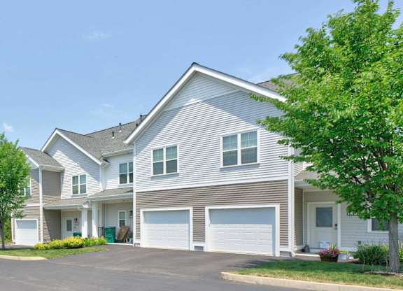 Gray townhomes with attached garages and individual entrances at Madison at Marshfield.