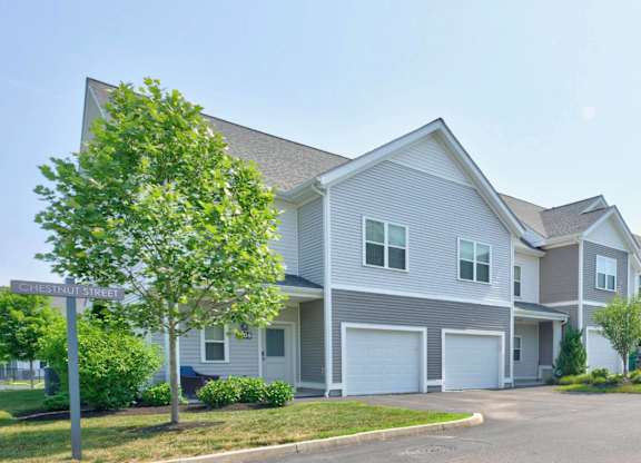 Townhome buildings with attached garages lining a residential drive.