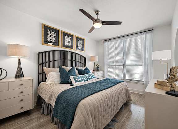 Serene bedroom with a statement headboard, ceiling fan, and oversized window for soft natural light