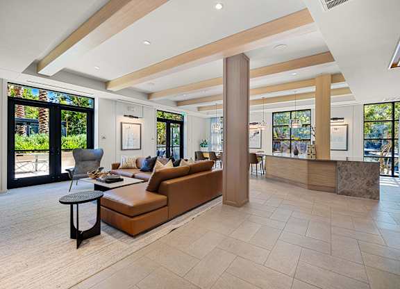 Stylish clubroom lounge with designer seating, wood accents, and walls of windows for gathering and relaxing