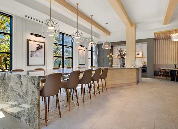 Sunlit dining area with oversized stone table and striking pendant lights, perfect for hosting gatherings