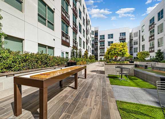 Outdoor shuffleboard table on a landscaped terrace designed for relaxed afternoons and social fun