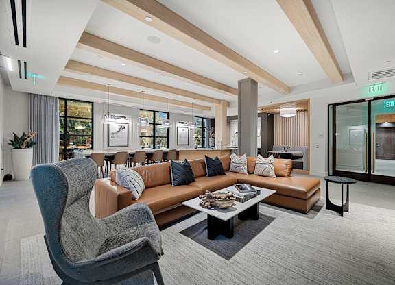 Stylish resident lounge with leather sectional, designer seating, and modern lighting for gatherings and relaxation