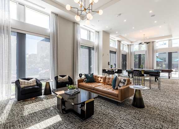 A modern living room with a large window and a grey carpet.