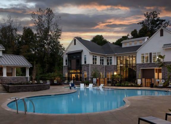 Evening Poolside Lounge with Clubhouse Backdrop and Landscaping