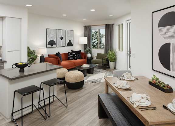 Open apartment with a kitchen island, dining table, orange sofa, and large living room windows.