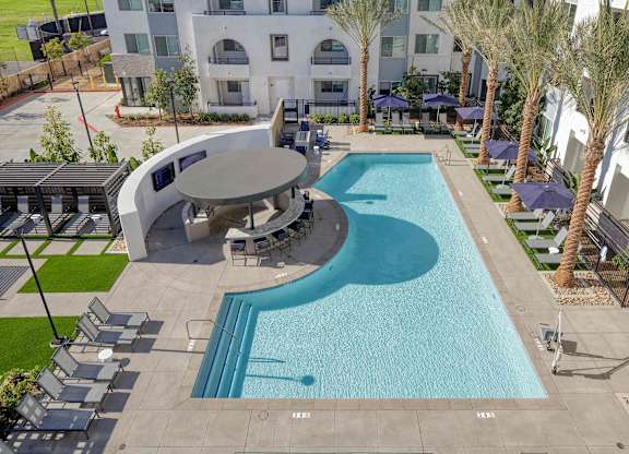 Elevated view of the resort-style pool, circular bar, lounge seating, and landscaped courtyard.