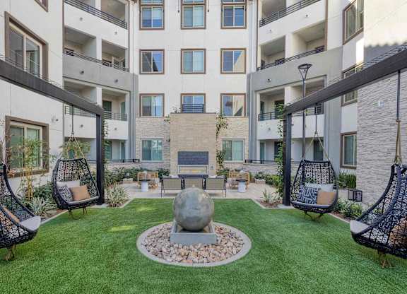 Zen Garden courtyard with hanging chairs, turf, landscaped planters, and a central water feature.