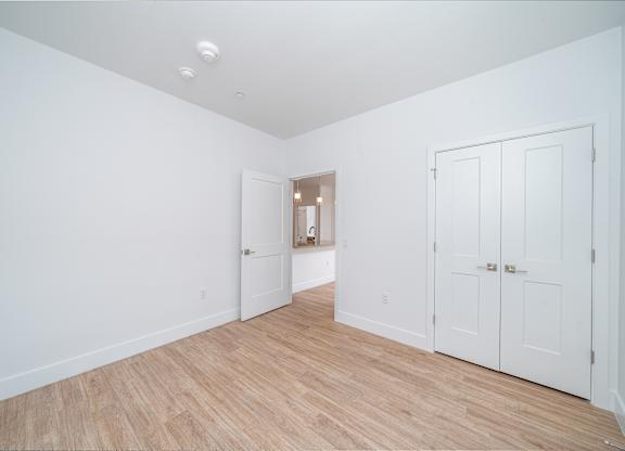 Empty bedroom with hardwood flooring and closet at Port & Main Apartments, Port Chester