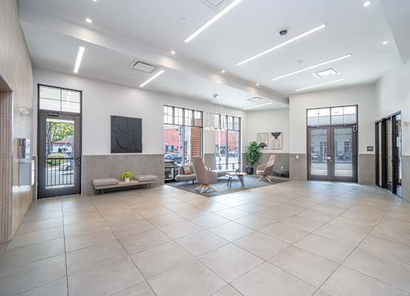 Bright lobby with modern seating and large windows at Port & Main Apartments, New York, 10573