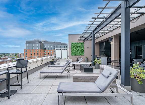 A rooftop patio with grey chairs and tables.