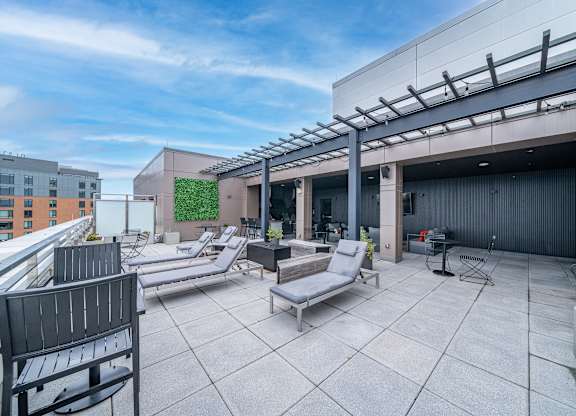 A rooftop patio with a table and chairs.