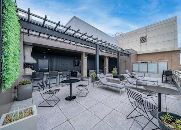 A patio with a table and chairs is surrounded by a building.