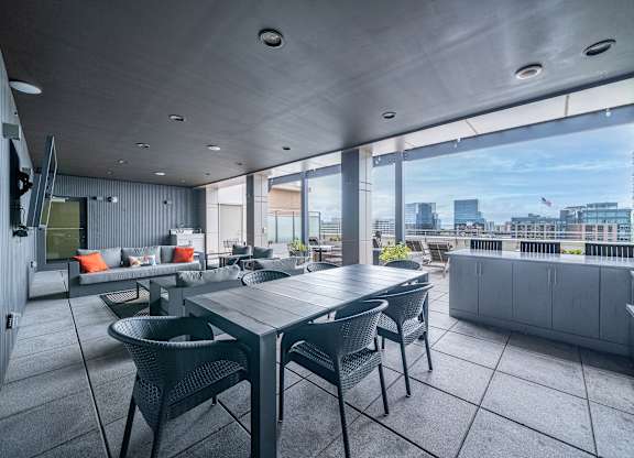 A modern outdoor dining area with a table and chairs.