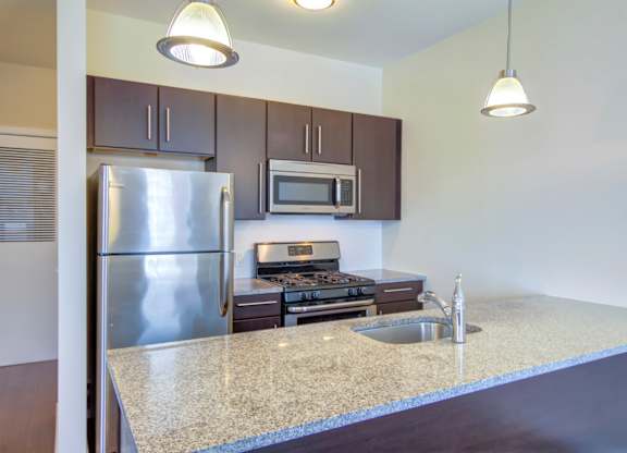 Kitchen with stainless steel appliances and island at 750 Summer Street Apartments, Stamford