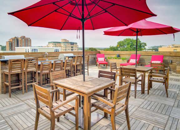 Rooftop dining area with red umbrellas and city views at 750 Summer Street Apartments, Connecticut, 06901